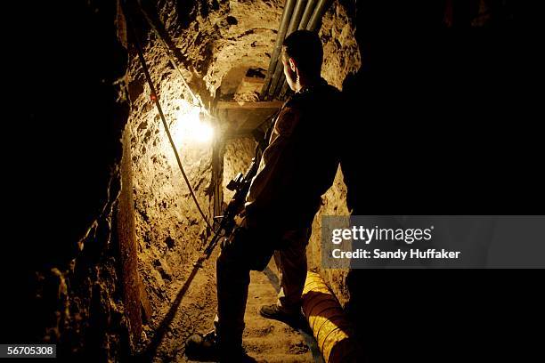 Police agent with U.S. Immigration and Customs Enforcement stands guard in a drug tunnel found along the Mexico/USA Border at a warehouse January 30,...