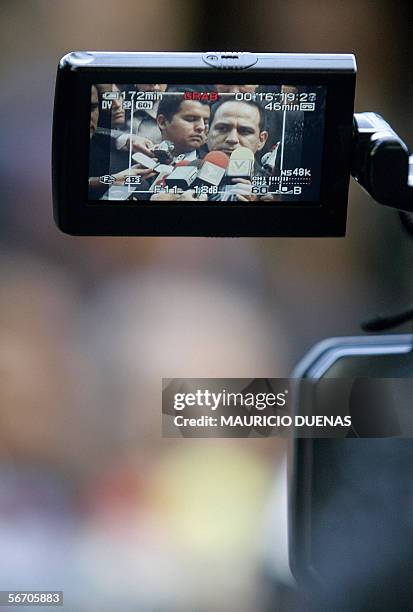 Jesse Chacon, ministro del Interior de Venezuela, es visto a traves de la pantalla de una camara de television mientras responde preguntas de...