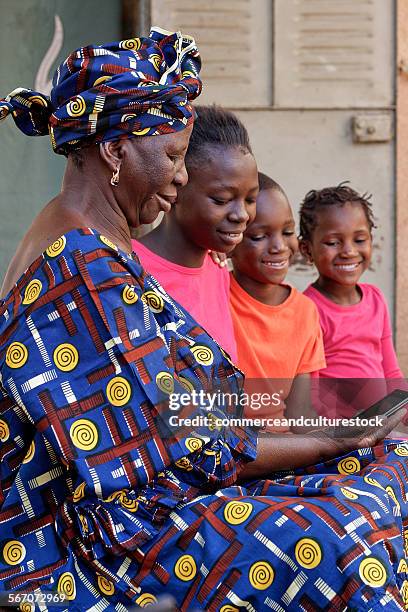 old woman and children with a mobile phone - commerceandculturestock stock pictures, royalty-free photos & images