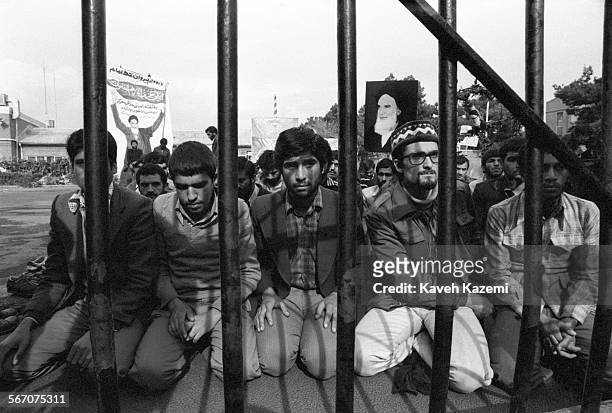 The "Students Following The Imam Khomeini Line" who hold the American hostages captive inside the compound seen during prayers on the compound behind...
