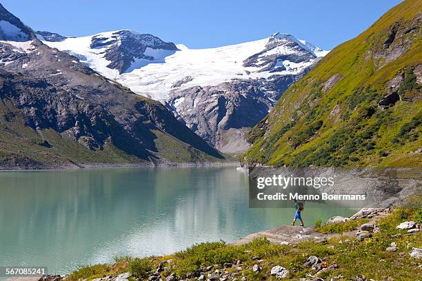 a male hiker near the mooserboden lake, during the glocknerrunde, a 7 stage trekking from kaprun to kals around the grossglockner, the highest mountain of austria. - hohe tauern stock pictures, royalty-free photos & images