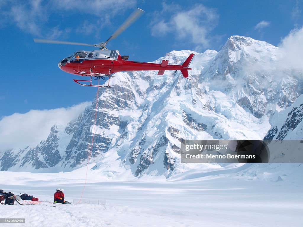 Mountain Ranger waiting to be picked up by a helicopter in Denali National Park, Alaska. Mount Hunter is in the background.