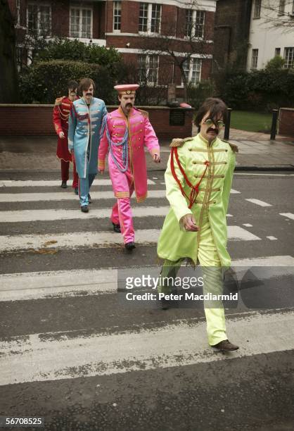Actors play the part of the Beatles crossing a zebra crossing outside the Abbey Road studios to publicise the sale of John Lennon's original 'A Day...