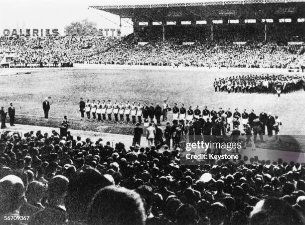 The Italian and Hungarian football teams stand to attention as their national anthems are played before the start of the World Cup final at the Stade...