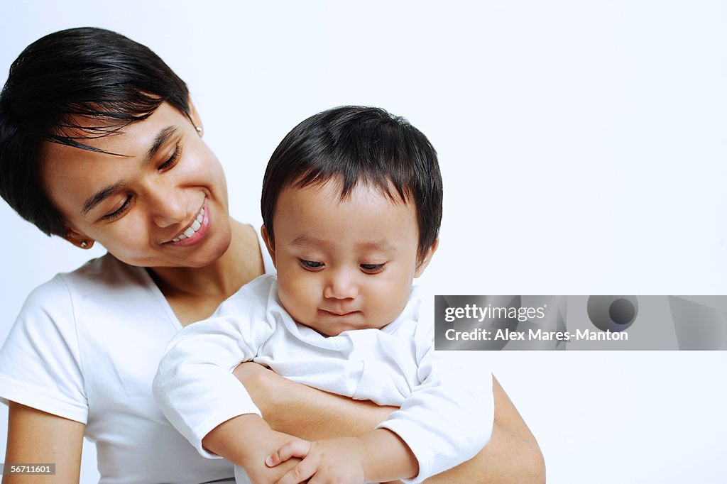 Mother with baby boy, looking down, portrait