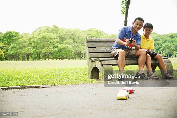 father and son playing with remote control cars - remote control car games stock pictures, royalty-free photos & images