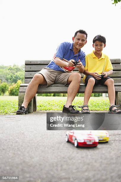 father and son playing with remote control cars - remote control car games stockfoto's en -beelden