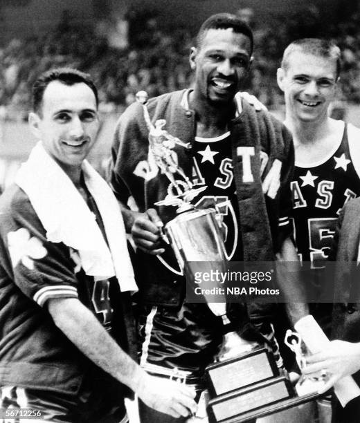 Bob Cousy, Bill Russell and Tom Heinson of the Boston Celtics pose with Bill Russell's NBA All-Star MVP Trophy after the 1963 NBA All Star Game circa...