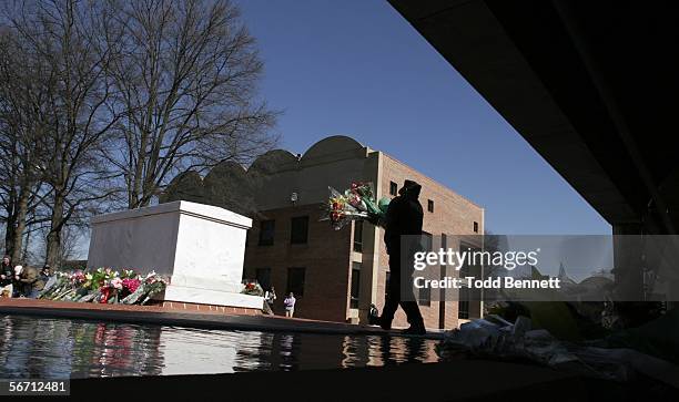 King Center employee, Sgt. Richart Cheatham, carries flowers to be placed at the base of Dr. Martin Luther King Jr.'s tomb, following news of the...