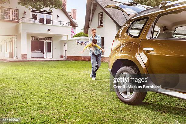 father and son are playing on the loan. - mid adult men fotografías e imágenes de stock