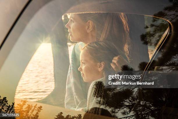 mother and daughter watching sunset. - family inside car stockfoto's en -beelden