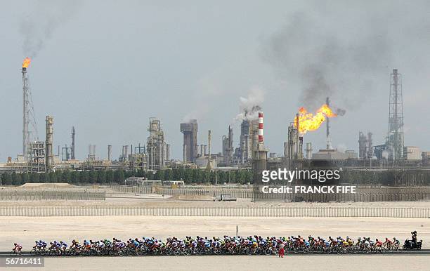 The pack rides past an oil refinery during the third stage of the 5th edition of the Tour of Qatar cycling race between Khalifa stadium and Al Khor...