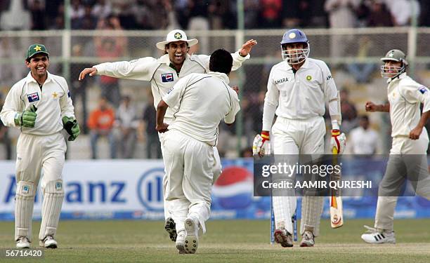 Pakistani spinner Danish Kaneria celebrates with his teammate after taking the wicket of Indian cricketer Anil Kumble during the fourth day of the...
