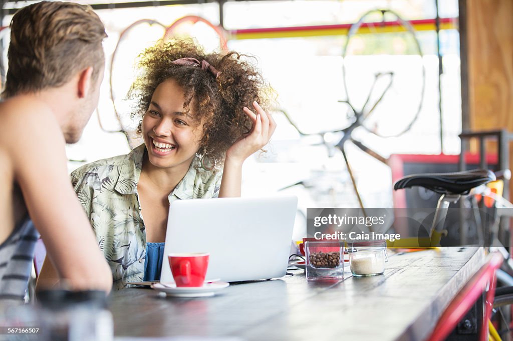 Couple talking at laptop in cafe