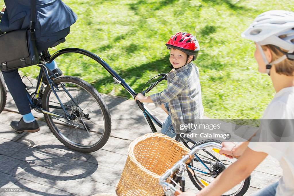 Portrait smiling boy riding tandem bicycle with father in park