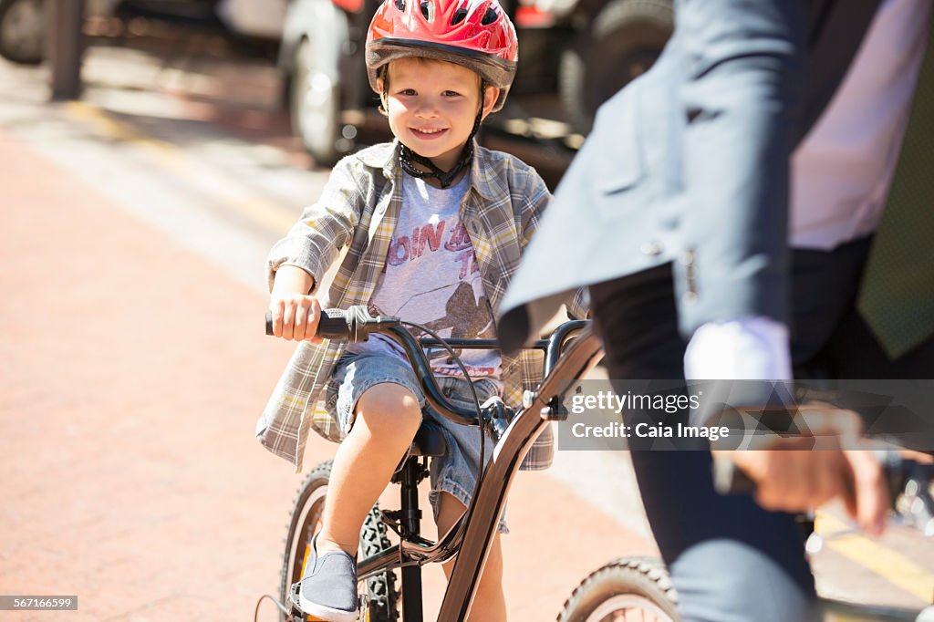 Portrait smiling boy riding bicycle on sunny road