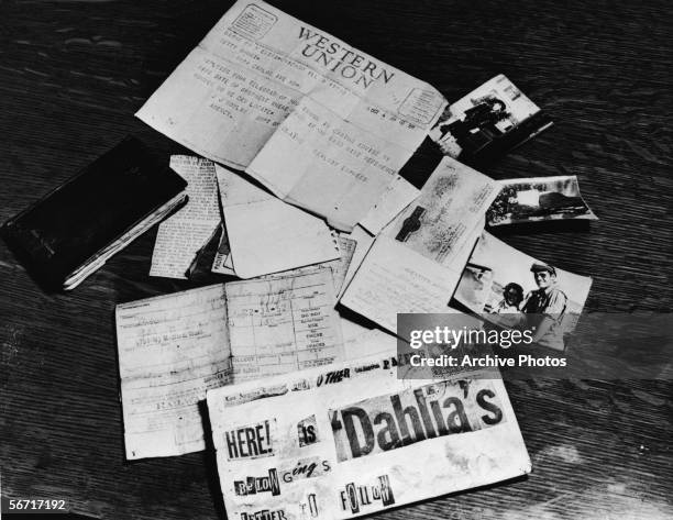 Evidence concerning the murder of American aspiring actress and murder victim Elizabeth Short , known as the 'Black Dahlia,' is strown across a table...