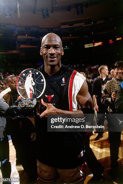 Michael Jordan of the Eastern Conference All-Stars poses with the 1996 NBA All-Star MVP Trophy after the Eastern Conference All-Stars defeated the...