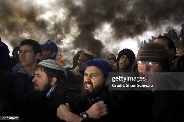 Israeli settlers stand arm in arm Israeli riot police February 1, 2006 in the West Bank outpost of Amona. The residents of Amona compose one of...