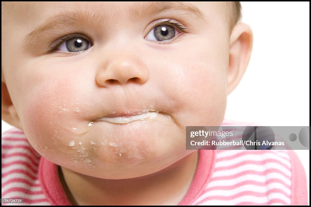 Close-up of a baby with food on chin