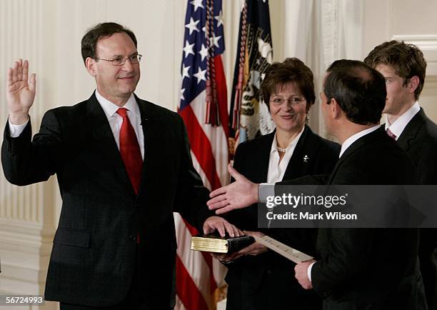 Samuel Alito is sworn in as Associate Justice of the United States Supreme Court while Chief Justice John Roberts reaches for a handshake while...