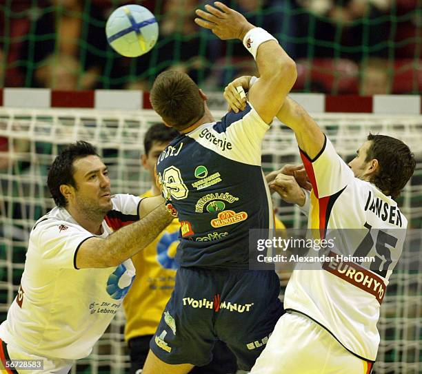 Andrej Klimovets and Torsten Jansen of Germany compete with Uros Zorman of Slovenia during the Handball Euro06 main round match between Slovenia and...