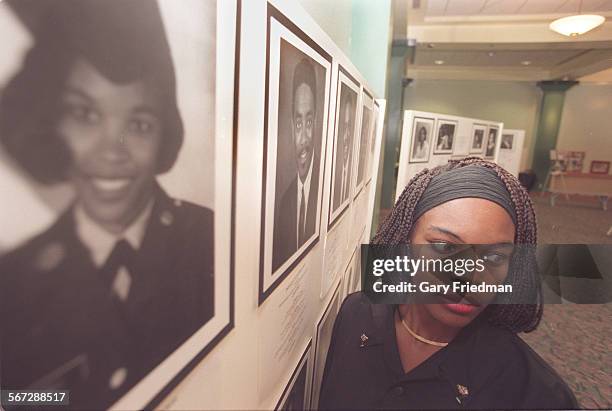 Jessica Irene JamesLewis, a licensed nurse and current Compton resident, with photogrpah of herself at far left as part of exhibit of former and...