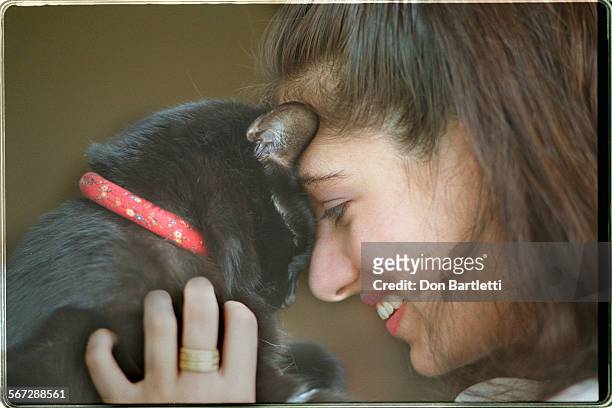 Python.Azharian.DB.7/24/96.Fullerton. Chris Azharian hugs her cat Mistoffelees in the apartment that she recently moved into. Unknown to Azharian, a...