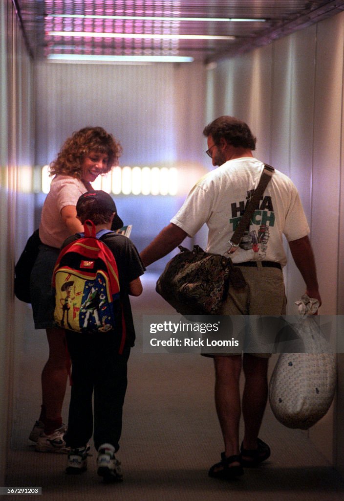 ME.flying.jetway.0728.RLSanta AnaSheila and Mark Hillinger, of Irvine, walk tenyearold Adam Hill