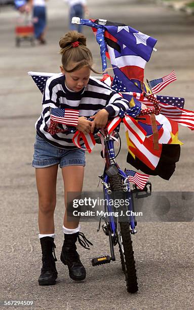 Tired Natalie Sydes , 10 pushes her bike the rest of the way during the Hidden Woods Eighth Annual 4th of July Parade and Party in Sherman Oaks on...