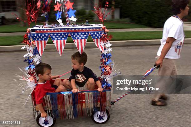 Jake Gershman , 4 and Tyler Peterson, 4 ride the parade route as nanny Estela Reyes pulls during the Hidden Woods Eighth Annual 4th of July Parade...