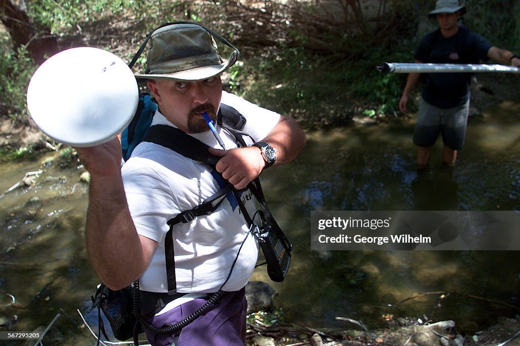 Heal the Bay stream team coordinator Mark Abramson, left, reaches for the antenna of his global sate