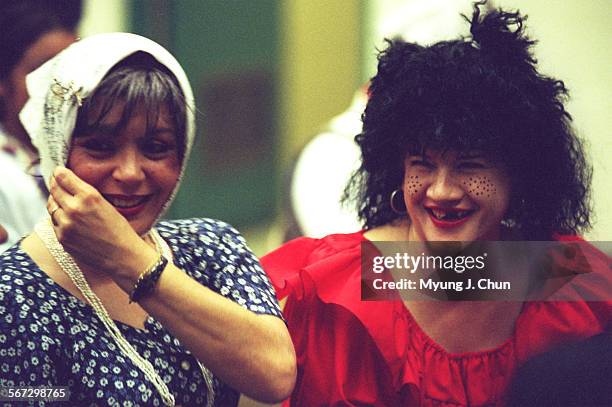 Dressed for their parts, Constelacion Teatral students Mirtha Cinelli and Carla Banuet share a laugh during a recent training session. The theater...