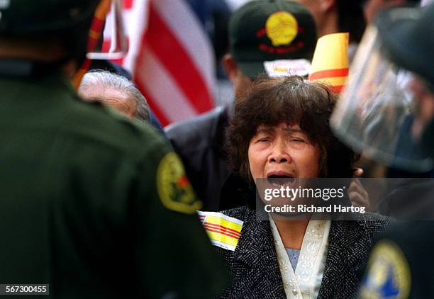 Protest.Woman.RH022099A tearyeyed Xuan Thi Nguyen shouts at police from behind the police lines outside Truong Van Tran's video store, Saturday...