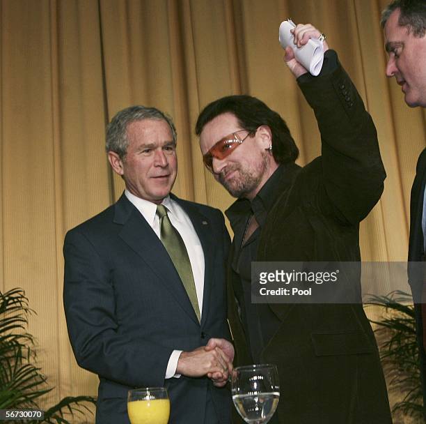 President George W. Bush and singer of the group U2, Bono, shake hands after Bono spoke at the National Prayer Breakfast February 2, 2006 in...