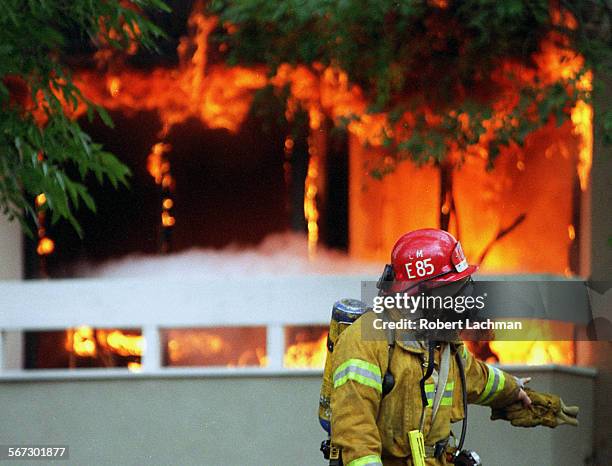 Fire.Flames.RDL A firefighter walks in front of the burning Freeway Businees Park office building at the corner of McCormcik Ave. And Pullman St. In...