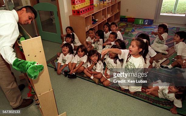 Ninos.3. Kl.10/8/97EAST LOS ANGELESAssistant teacher Angel Granados at the Centro De N inos child Care Center in East Los Angeles gives three and...