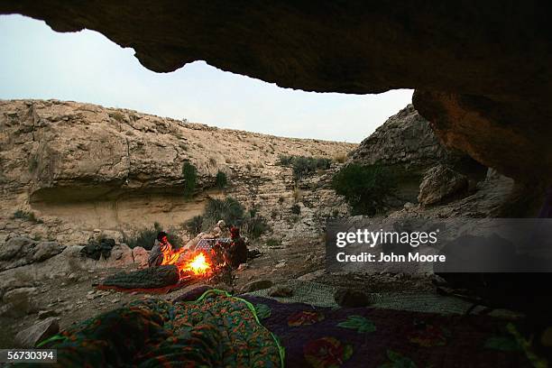 Marri tribal rebels warm themselves after waking at a rebel camp outside of the town of Kahan February 1, 2006 in the Pakistani province of...