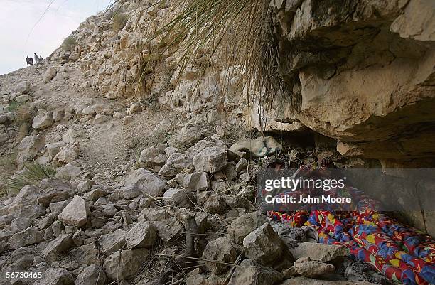 Marri tribal guerrilla sleeps under a rock ledge after finishing night guard duty at a rebel camp outside of the town of Kahan in the Pakistani...