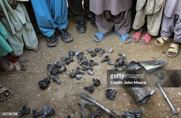 Villagers gather around the debris of mortar shells after returning to the town of Kahan on February 1, 2006 in the Pakistani province of...