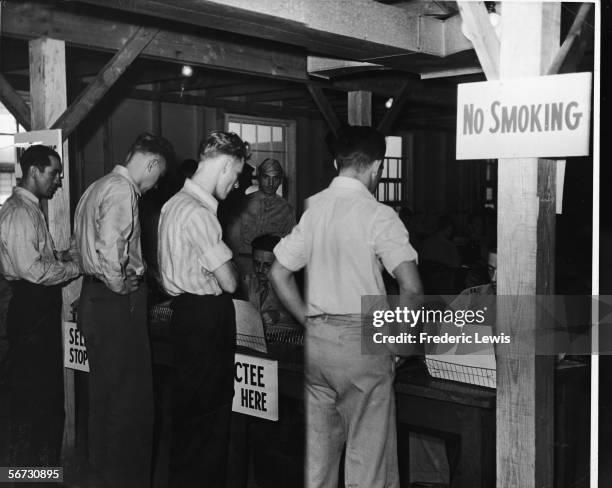 Military recruits stand in line to receive the results of their physical examinations at the Governer's Island Pre-Induction Center, New York, New...