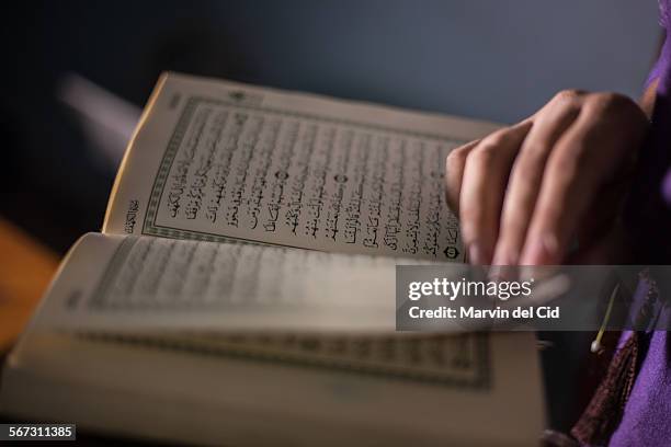 reading the quran - coran photos et images de collection