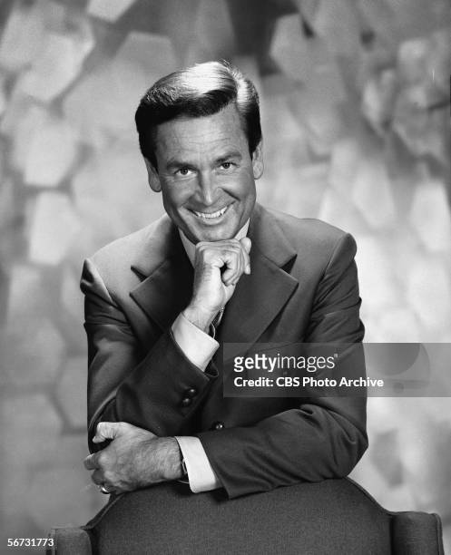 American game show host Bob Barker leans against a chair and poses with his chin on his hand in a publicity still for the Miss Universe Beauty...