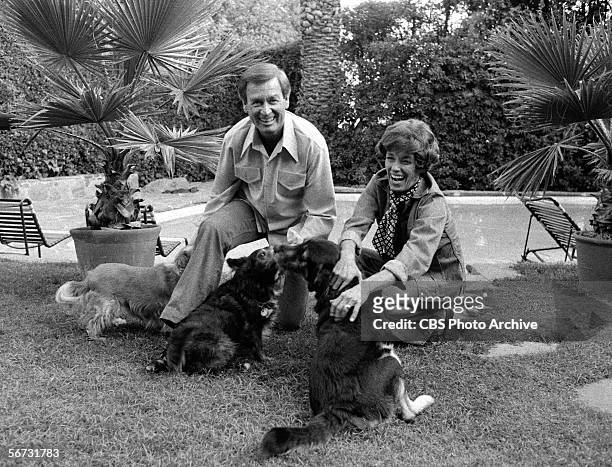 American game show host Bob Barker and his wife Dorothy Jo play with three dogs in their back yard, November 4, 1977.