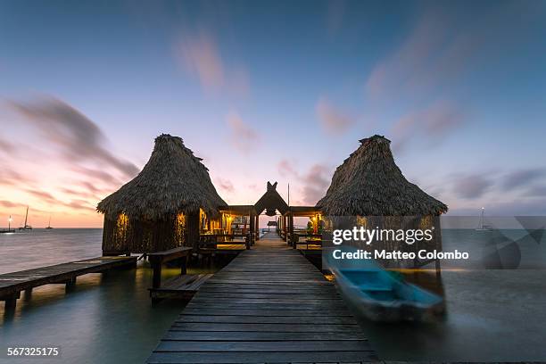 overwater bungalow and jetty at sunset, belize - belize stock-fotos und bilder