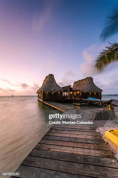 overwater bungalow and jetty at sunset, belize - ambergris caye stock pictures, royalty-free photos & images