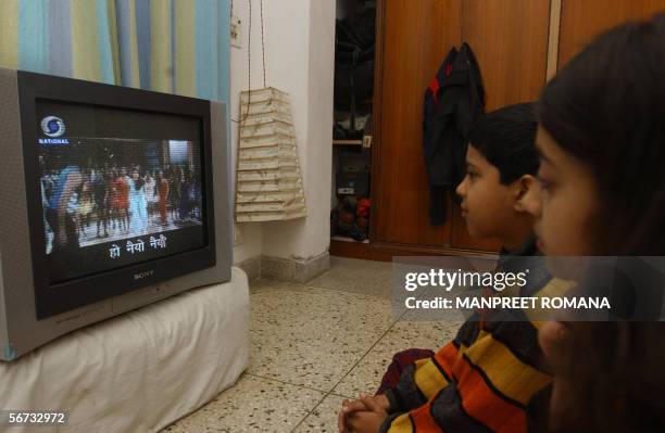 In this picture taken 22 January 2006, Indian children watch 'Rangoli' a Hindi film on television with subtitles in New Delhi. Indian film producer...