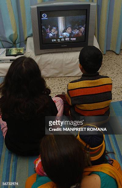 In this picture taken 22 January 2006, Indian children watch 'Rangoli' a Hindi film on television with subtitles in New Delhi. Indian film producer...
