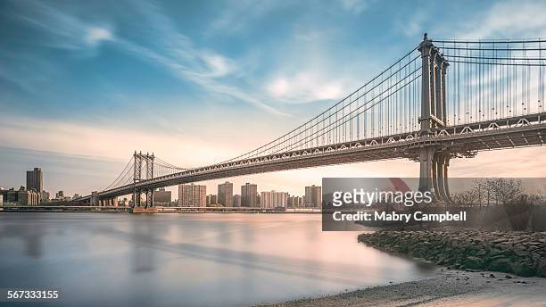 manhattan bridge spans east river in new york city - bridge stock pictures, royalty-free photos & images