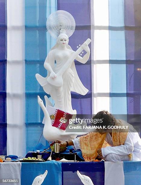 Bangladeshi Hindu priest prepares to offer prayers in front of an idol of the Hindu Goddess of Learning, Saraswati, during the annual festival of...